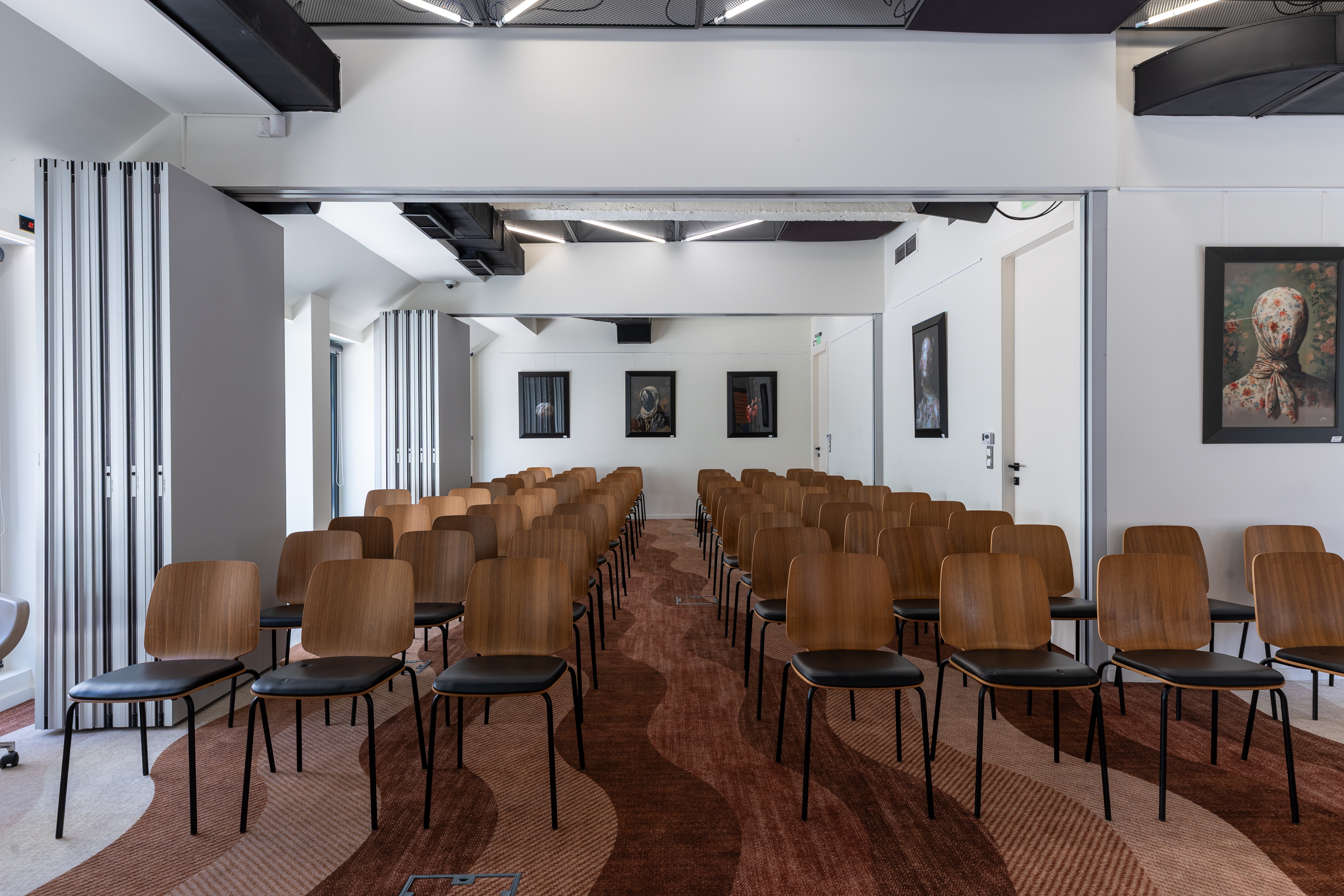 Talk set-up with rows of chairs and artworks