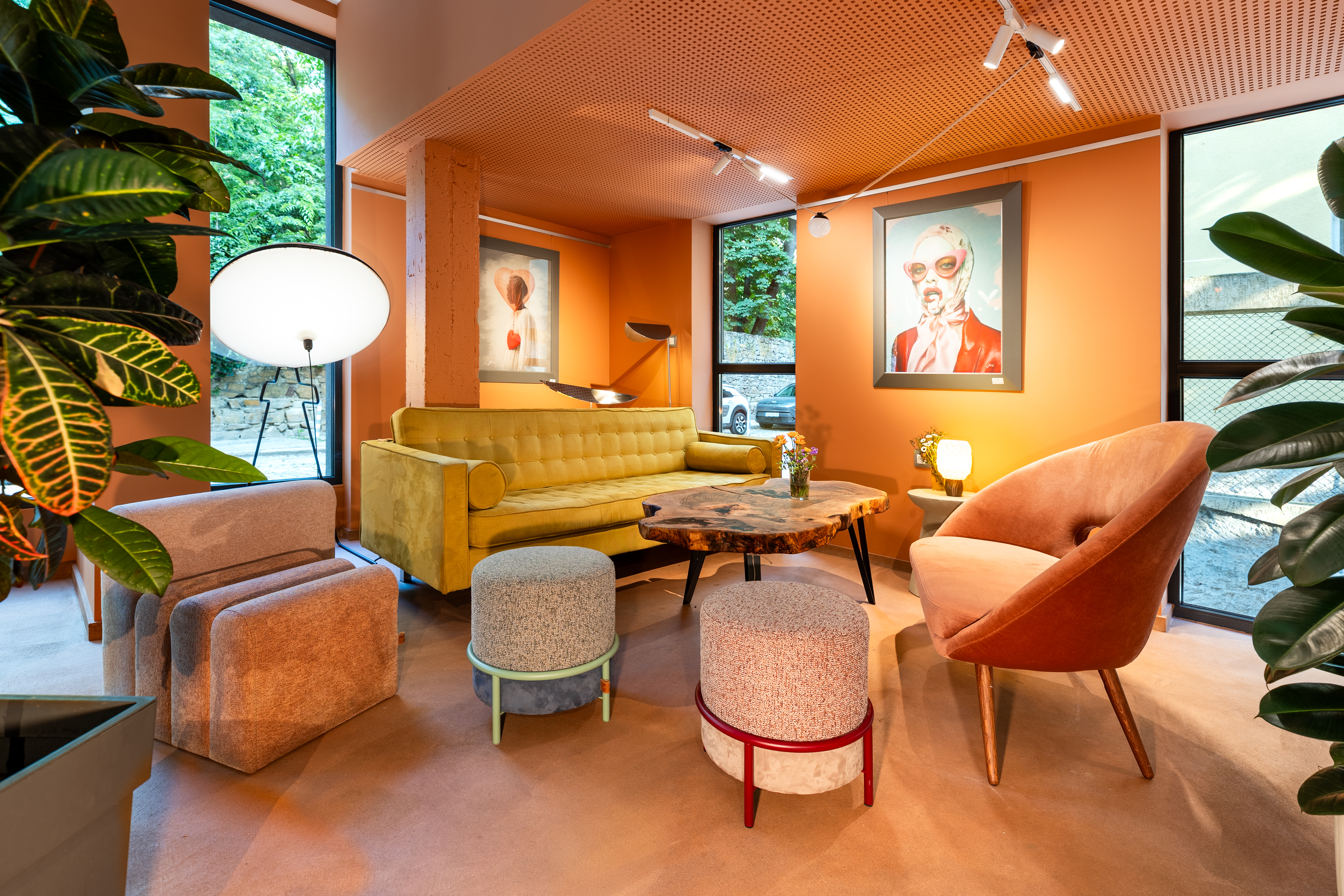 Lounge with mustard sofa, artworks and tall windows