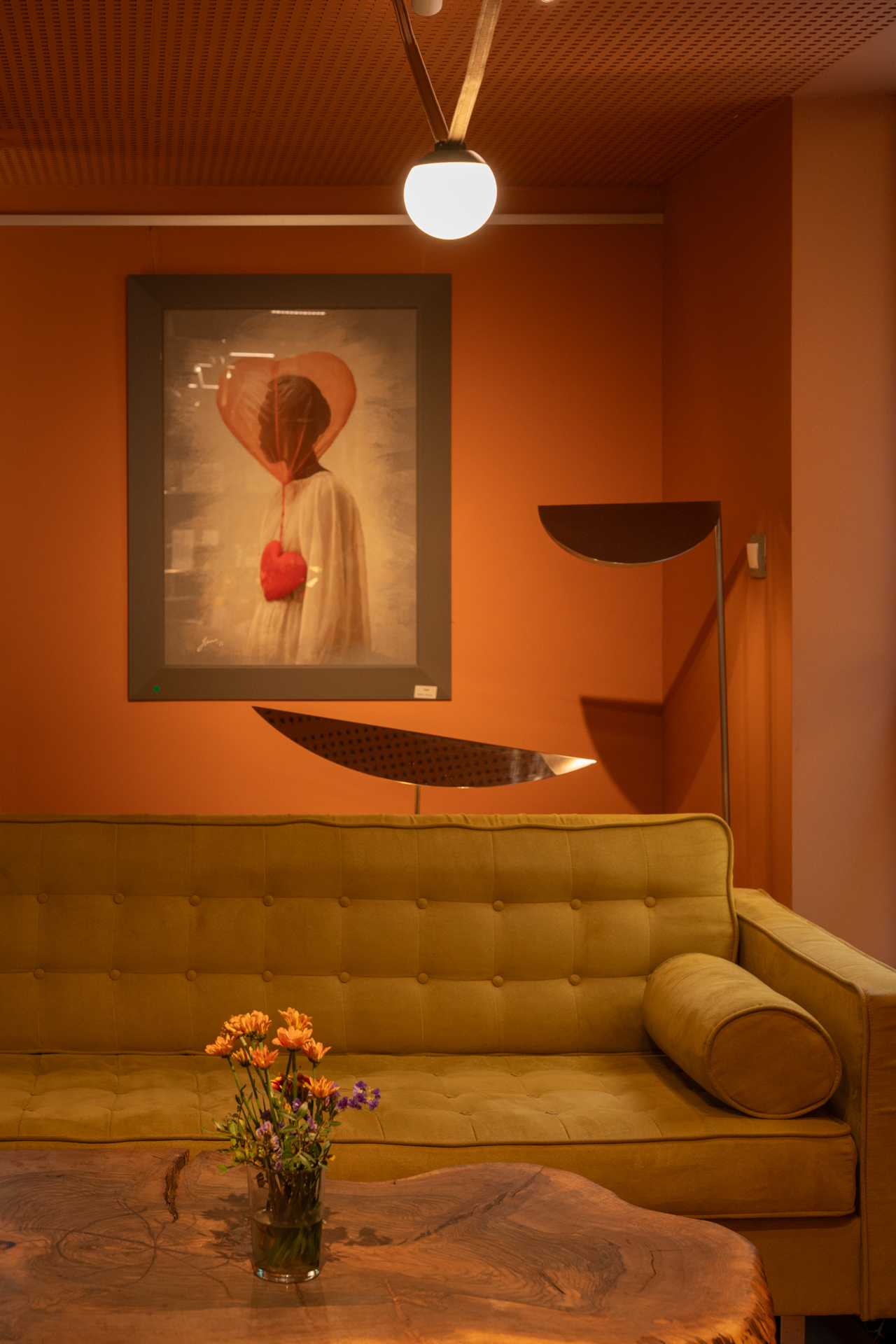 Painting above a mustard sofa and a live-edge wooden table