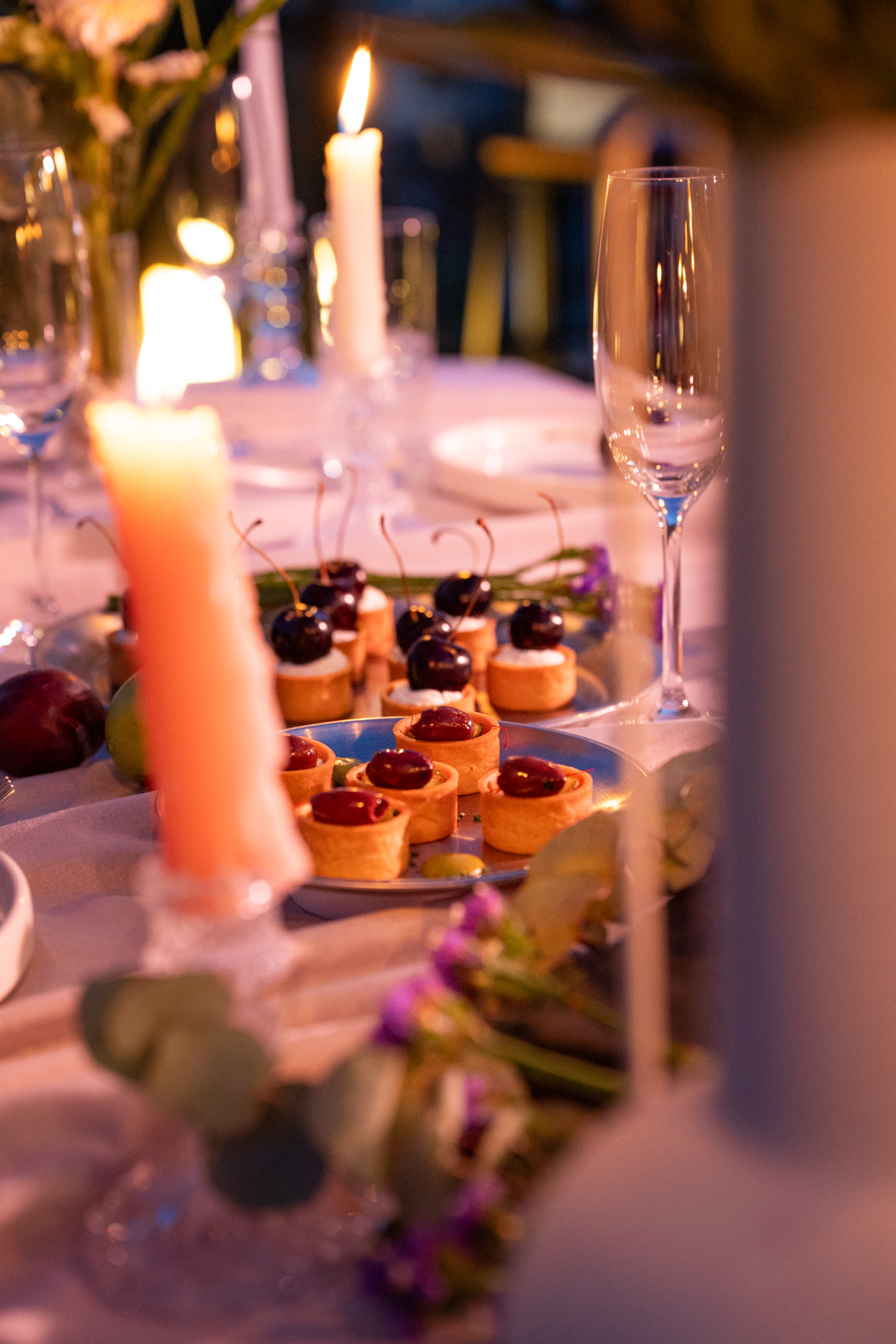 Candlelit table with cherry tarts